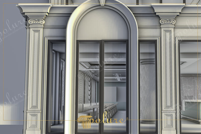 Açık gri tonlarında boyanmış dış cephede yüksek kemerli cam girişin etrafına uygulanan yivli gövdeli pilaster sütunlar ve pencere söveleri.