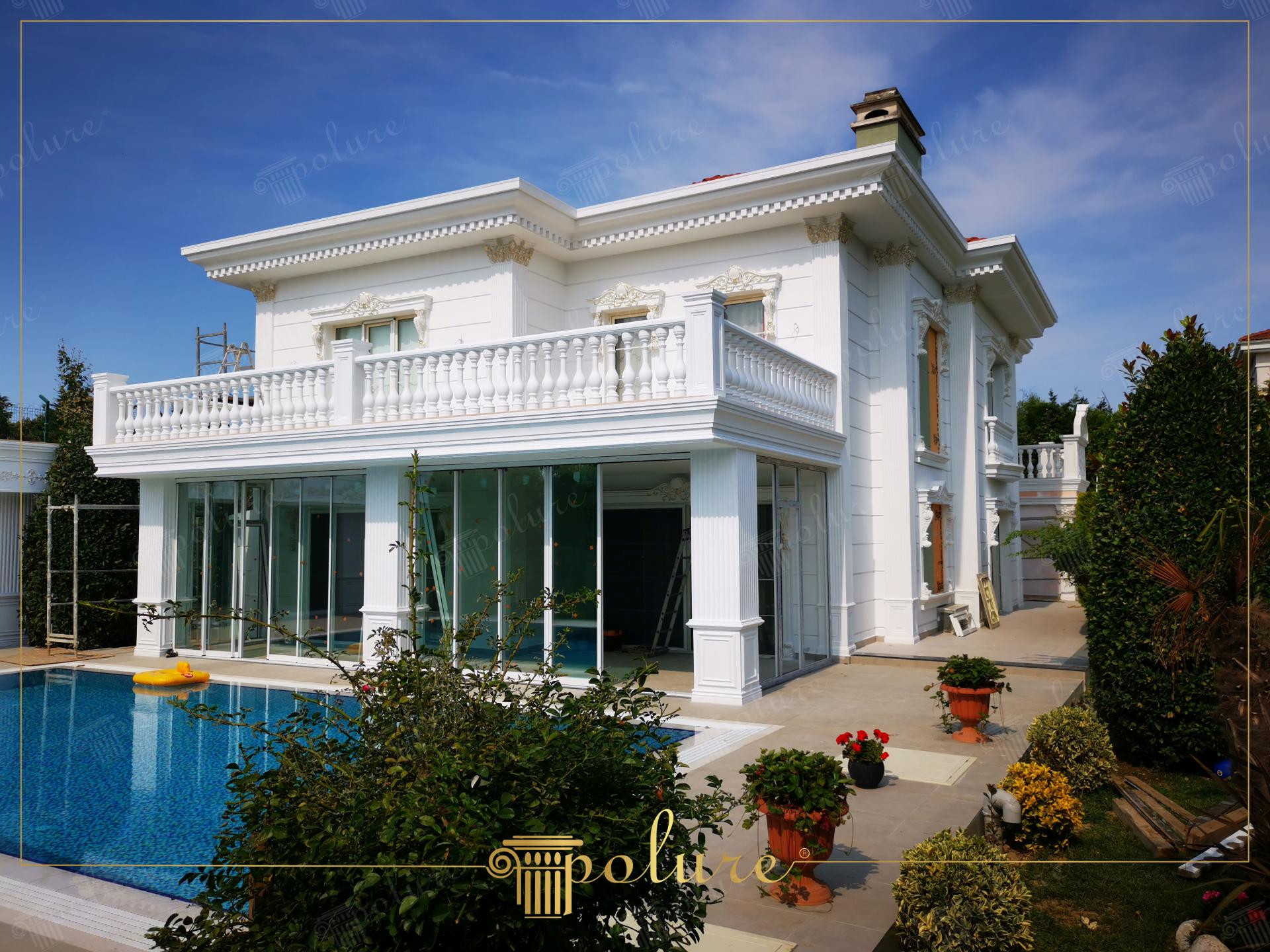 Lüks villa dış cephesinde uygulanan beyaz renkli pencere söveleri, kavisli taçlar, dikey sütunlar ve balkon korkulukları.