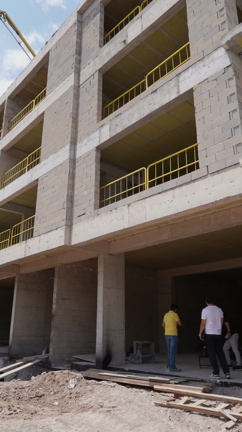 Kaba yapıdaki çok katlı binanın balkon açıklıkları ve kolonları görülüyor.