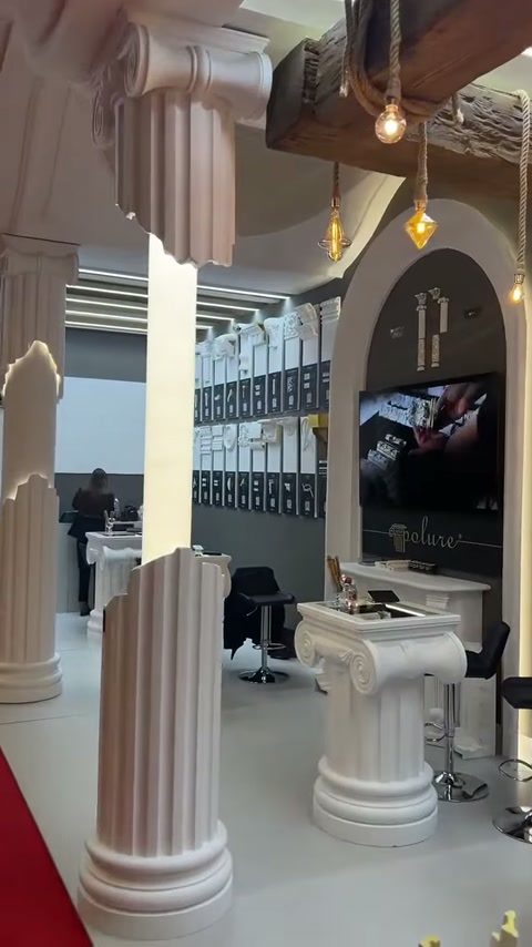 Antik başlıklı sütunlar, kemerli duvar bölümü ve teşhir masası görülüyor