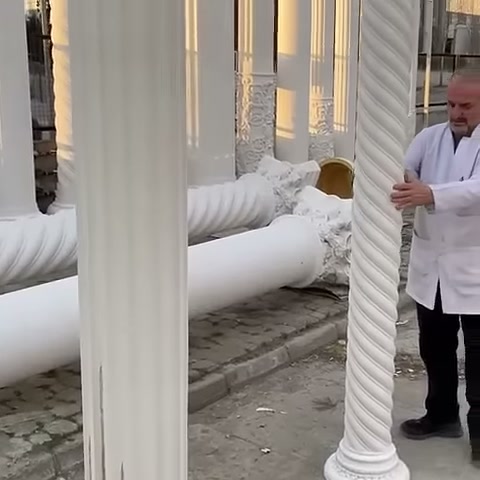 Usta, burmalı ince sütunun yanında durarak gövdeyi gösteriyor