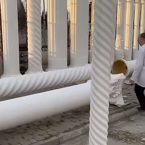 Burmalı sütun önde dururken yatay gövdeler arka planda sıralanıyor