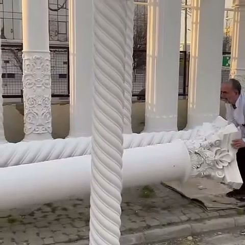 Usta, süslü sütun başlığını zeminde dikkatle yeniden konumlandırıyor