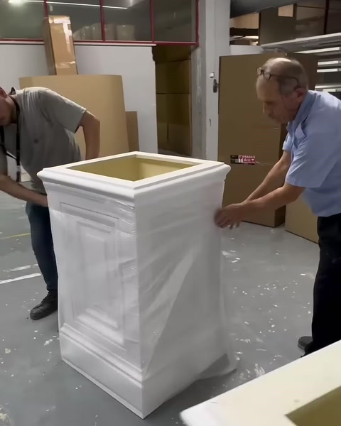 Büyük pilaster kaidesi iki çalışan tarafından dikkatle taşınıyor