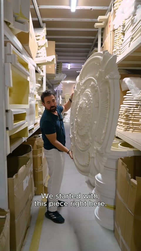 Büyük kabartmalı madalyon, depo koridorunda tasarımcı tarafından dikey tutuluyor.