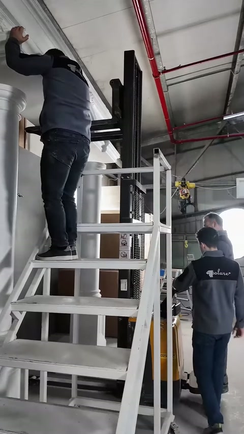 Merdivendeki usta, yatay dekoratif parçanın seviyesini gözle kontrol ediyor.