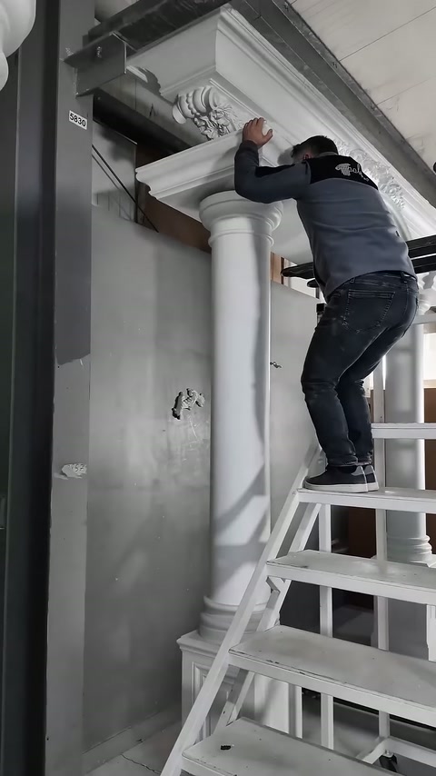 Çalışan, dekoratif tacın uç kısmını duvar yanında hizalıyor.