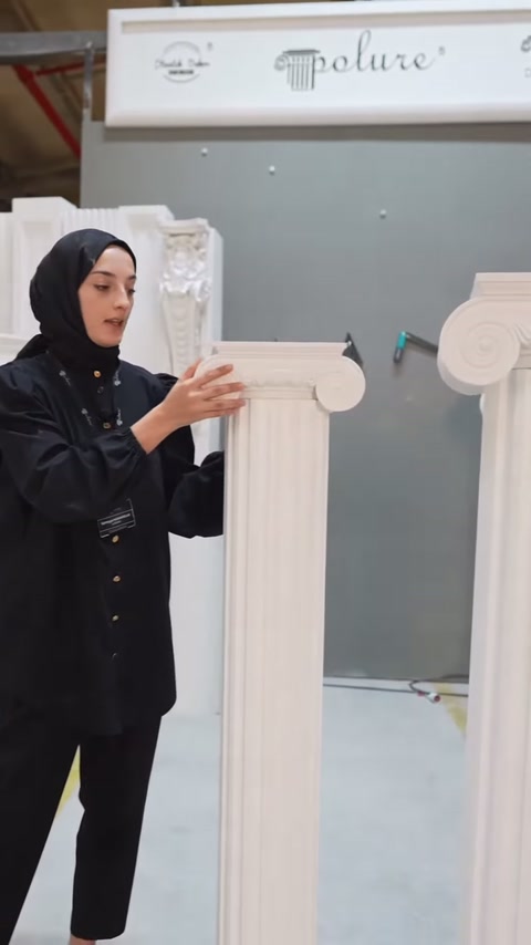 Volütlü başlığın kıvrımlı kenarı sunucu tarafından yakından gösteriliyor