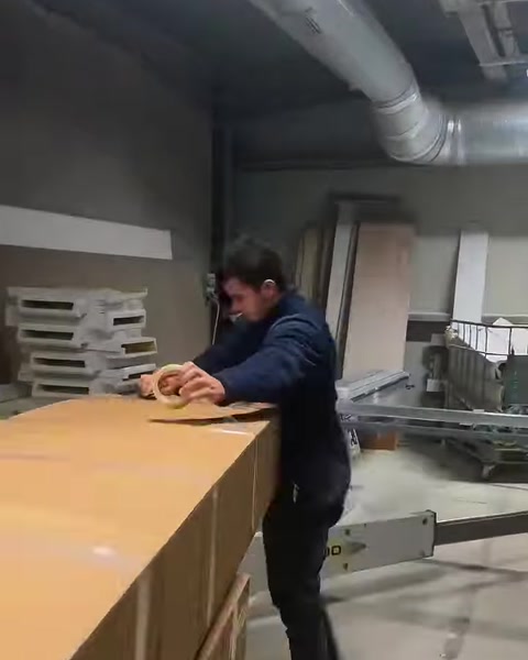 Büyük levha üzerinde ölçüm ve hazırlık yapan atölye çalışanı