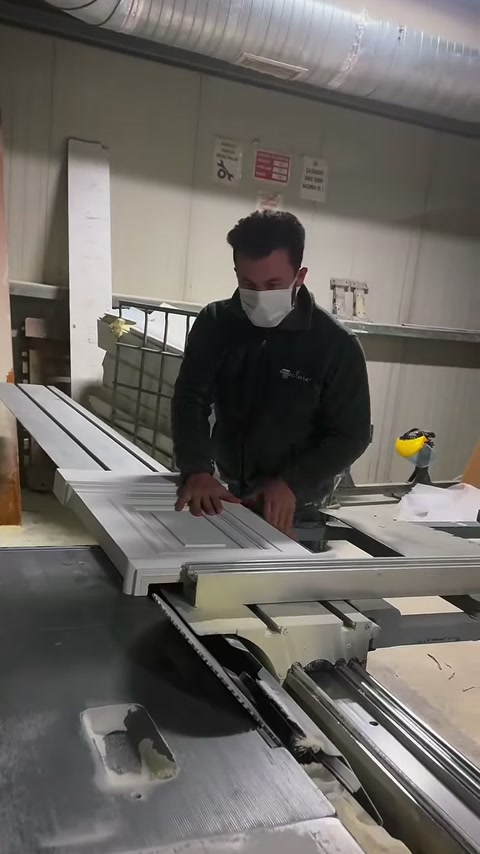 Katmanlı beyaz profiller çalışma tezgâhında kesime uygun konuma getiriliyor.