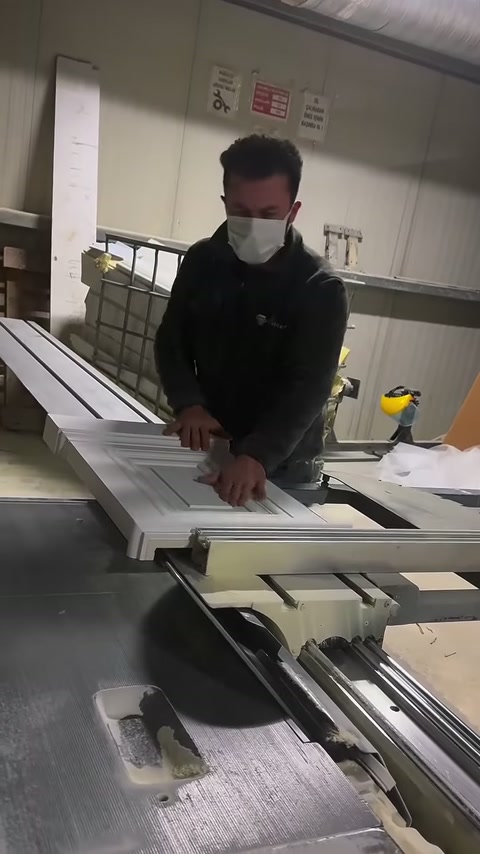 Usta, çizgili yüzeyli profilleri makinenin kesim bölümüne yaklaştırıyor.
