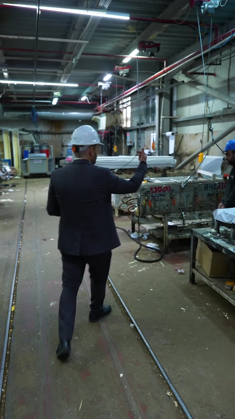 Üretim alanında büyük kalıp üzerinde çalışan fabrika personeli