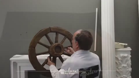 Sunucu şömine üzerindeki koyu dekoratif teker modeline eliyle dokunuyor