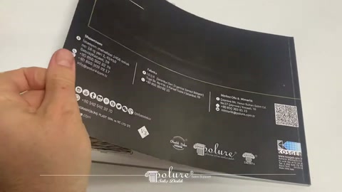 Sunucu ürün kataloğunun koyu renkli arka kapağını tutuyor