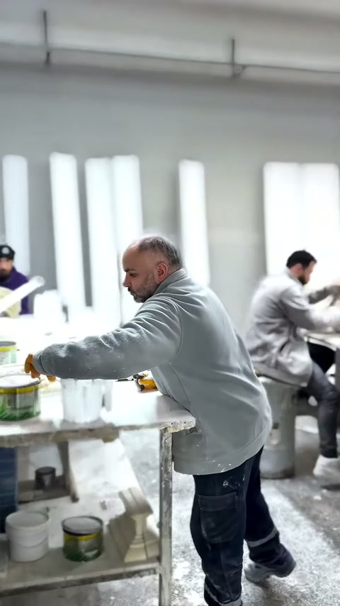 Usta, masadaki dekoratif parçayı elindeki araçla dikkatlice düzenliyor.
