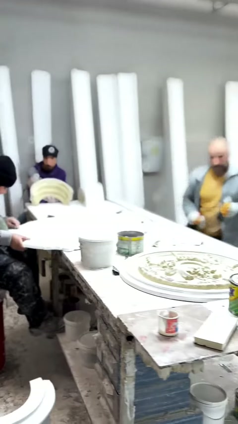 Yuvarlak kabartmalı süsleme, kaplar ve aletlerle birlikte tezgahta duruyor.