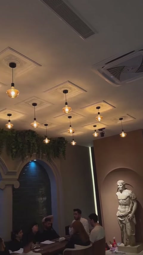 Dekoratif tavan panelleri restoran masasının üzerinde düzenli biçimde uzanıyor.