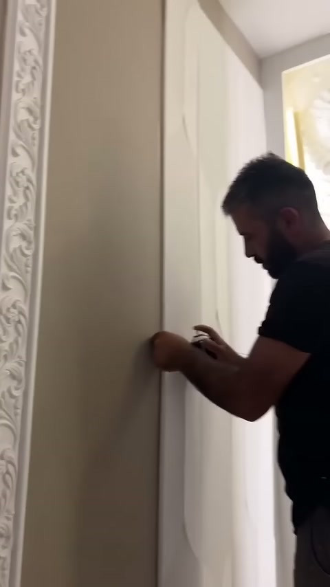 Usta beyaz kaplamanın kenar çizgisini eliyle bastırarak sabitliyor.