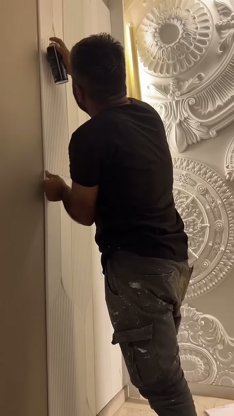Usta panel kenarını avucuyla destekleyip üst kısma sprey tutuyor.