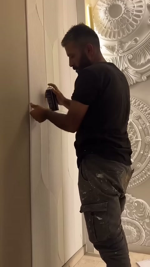 Montajcı elindeki kutuyla panelin orta kenarında işlem yapıyor.