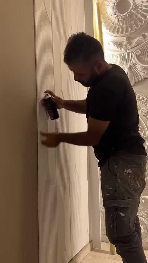 Beyaz panel kenarına sprey tutulurken diğer elle hizalama sağlanıyor.