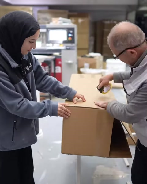 Çalışanlar, ürün kutusunun kenarlarını kapatma öncesinde hizalıyor
