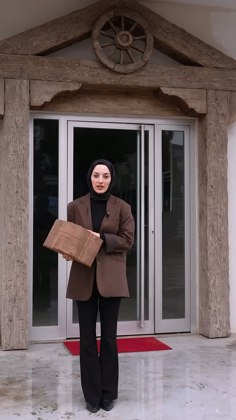 Sunucu kraft kağıda sarılı bir kiriş numunesini giriş önünde açıyor
