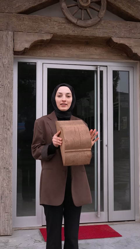 Sunucu paketten çıkardığı kiriş numunesini giriş önünde gösteriyor