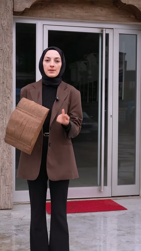 Sunucu giriş önünde elinde sarılı ürün numunesiyle konuşmaya başlıyor