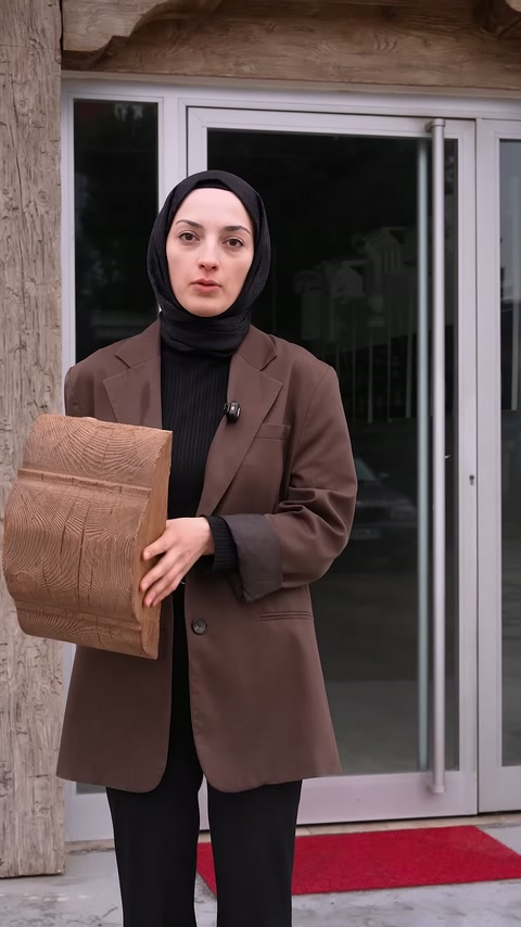 Sunucu giriş önünde elindeki ürün numunesiyle videoyu tamamlıyor