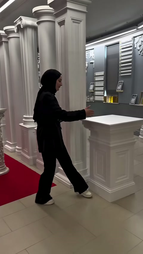 Tanıtıcı, kare sütun kaidesinin yanındaki geniş tablayı kaldırıyor.