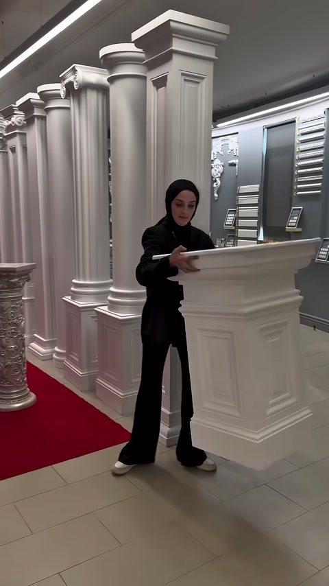 Tanıtıcı, düz tablayı kare sütun gövdesinin üzerinde dengeliyor.