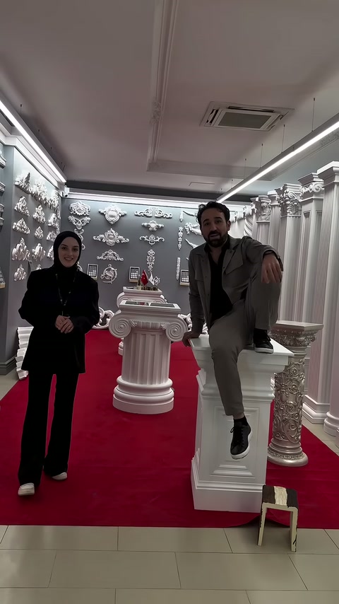 Bir erkek, kare sütun sehpanın yanındaki basamağa ayağını koyuyor.