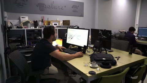 Tasarımcı geniş çalışma masasında kemer modelini bilgisayarda geliştiriyor