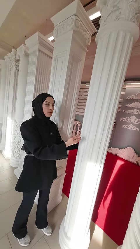 Sunucu, yivli sütunun gövdesine dokunarak modeli inceliyor.