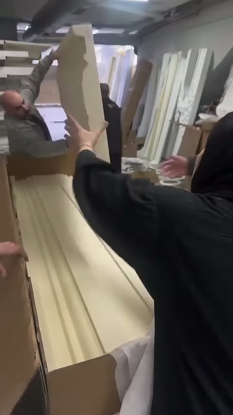 Çalışan dar profil parçasını açık kutunun üzerinde kaldırıyor