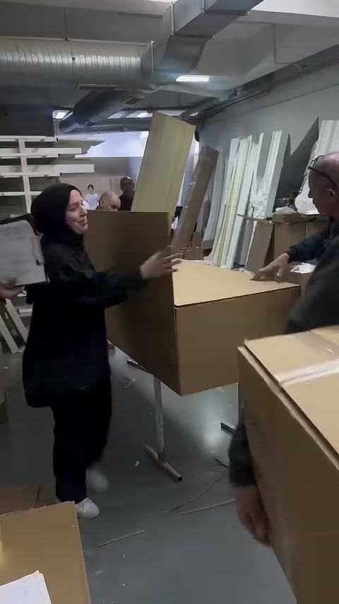 Çalışan uzun dekoratif profili açık ambalaj kutusuna doğru yönlendiriyor