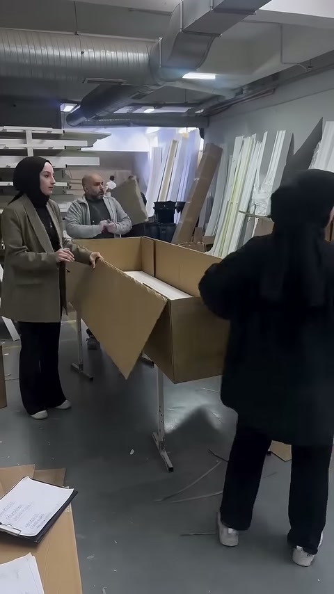 Uzun karton kapak dekoratif profillerin üzerine kapatılmak üzere tutuluyor