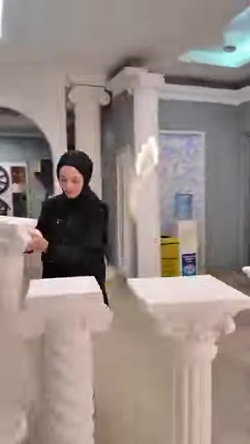 Farklı yüksekliklerdeki beyaz sehpa ve dekoratif sütunlar sergileniyor.