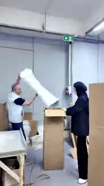 Uzun beyaz dekoratif gövde üretim alanında dik konuma kaldırılıyor.