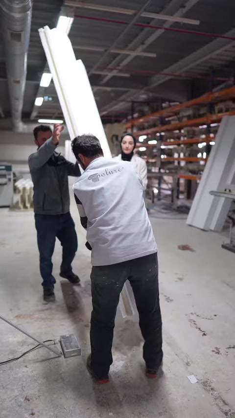 İki çalışan, büyük boyutlu dekoratif profili dik konuma getiriyor.