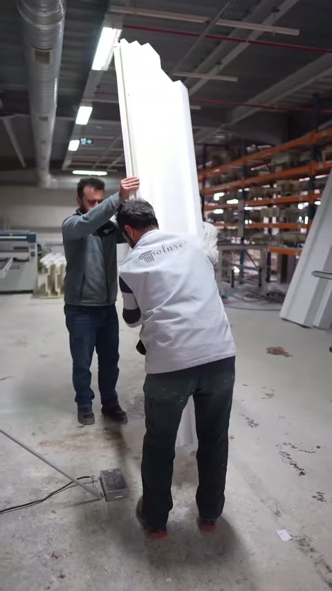 İki çalışan, uzun beyaz kat silmelerini dik konuma kaldırıyor.