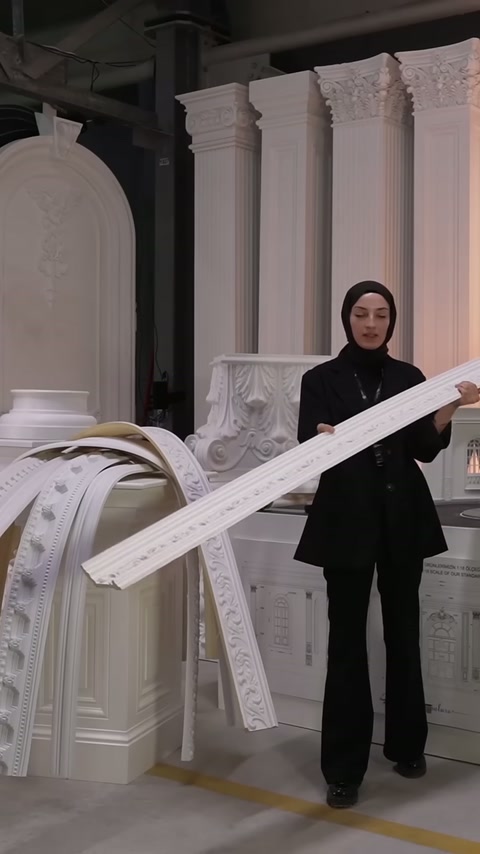 İşlemeli kartonpiyer, dekoratif sütunların önünde çapraz konumda sergileniyor