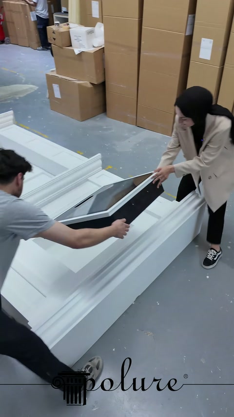 Çalışanlar atölyede siyah iç bölümü şömine boşluğuna birlikte oturtuyor.