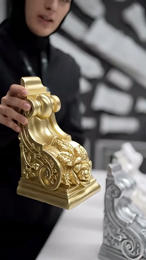 Altın kaplamalı payandanın spiral bezemeleri elde yakından inceleniyor