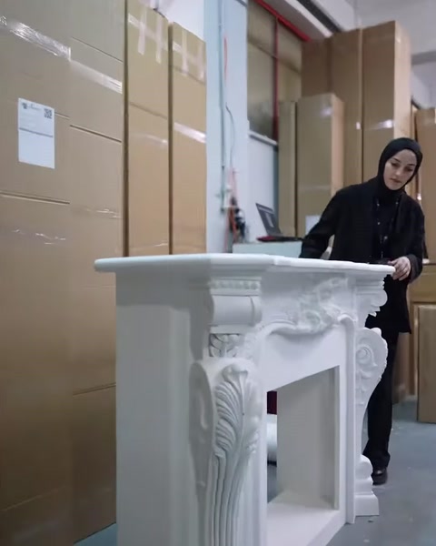 Beyaz, kabartma bezemeli dekoratif şömine modeli atölyede sergileniyor