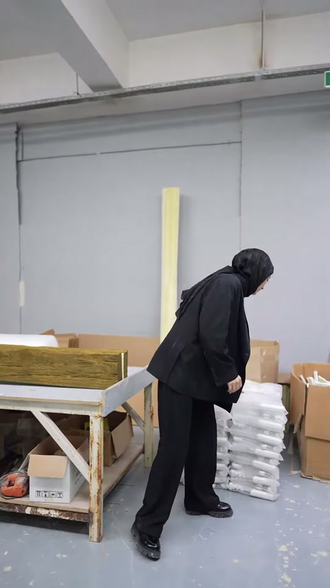 Çalışma tezgâhında çok sayıda beyaz dekoratif parça istiflenmiş durumda.