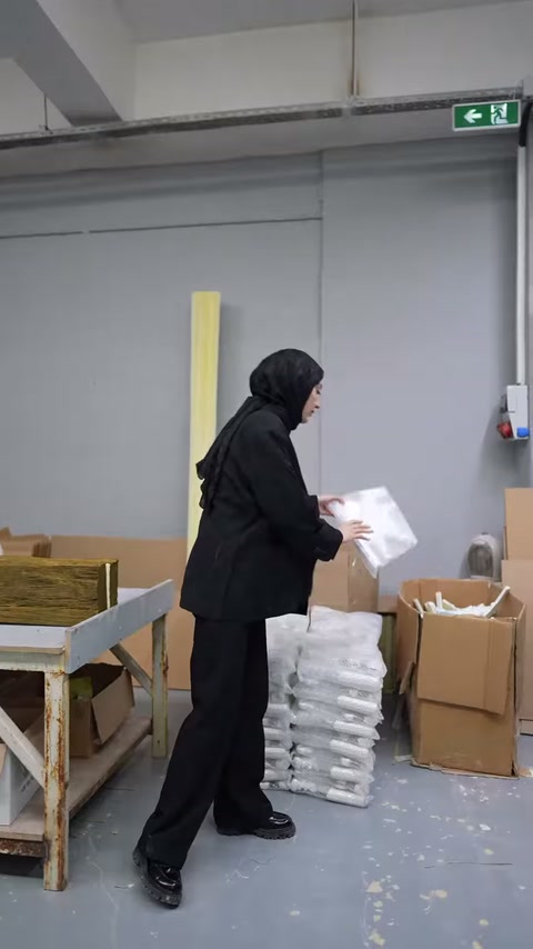 Beyaz süsleme parçaları, karton kutuların yanında düzenli biçimde yığılıyor.