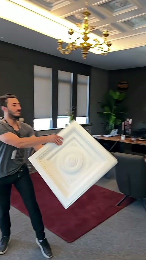 Beyaz kabartmalı panel, tavandaki kaset düzeniyle birlikte sergileniyor.