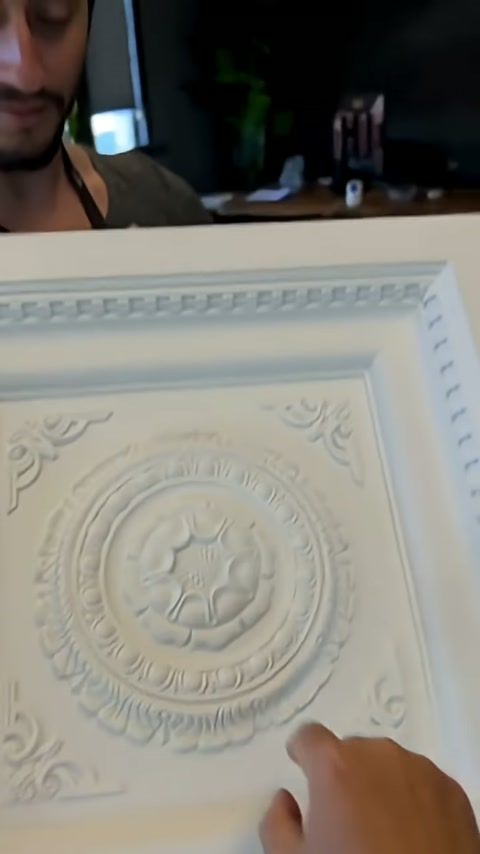 Sunucu parmağıyla kare panelin merkez çevresindeki süslemeyi anlatıyor.